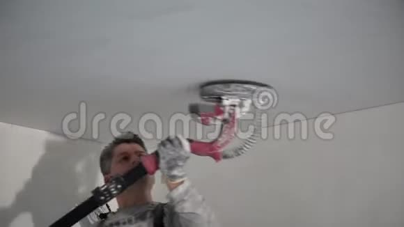 男建筑工人用砂光机打磨天花板表面视频的预览图