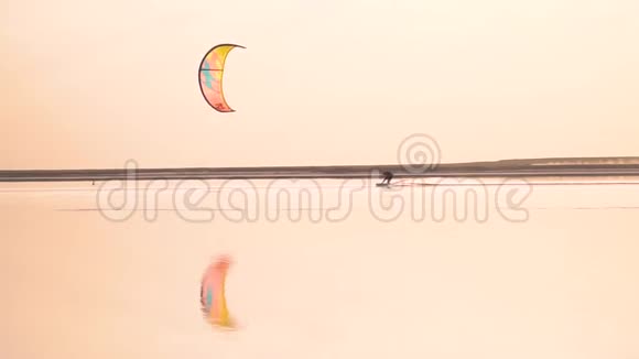 风筝驾驶着一只明亮的训练风筝在湖面上航行视频的预览图