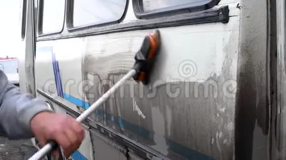 一个人在露天洗一辆脏公共汽车视频的预览图