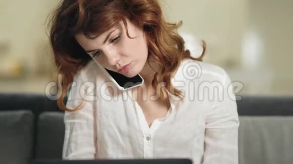 微笑的女人坐在工作场所拿着笔记本电脑商务女性打电话视频的预览图