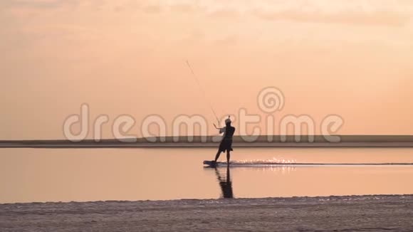 湖上的一个人控制着一只训练风筝慢慢地在水面上滚动视频的预览图
