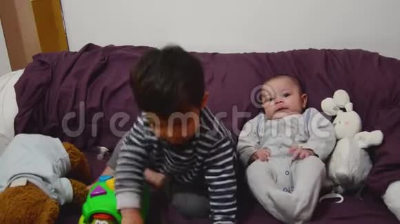可爱的两岁男孩在玩海龟教育玩具而他的小弟弟正在看着和微笑视频的预览图