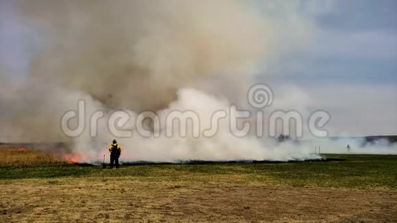 用消防队员为草原修复工作进行草火燃烧视频的预览图