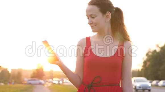 有智能手机的女人站在马路对面开车视频的预览图