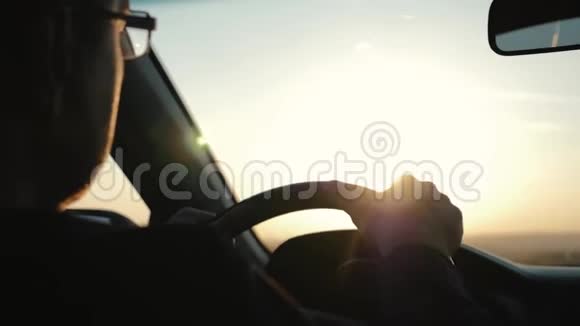 一个人在夕阳的照耀下骑着他的车后视镜的反光视频的预览图