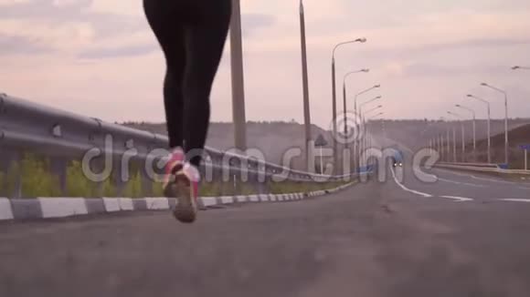 积极的生活方式和保健一个穿着白色T恤和轻便运动鞋的运动女孩走在后面的一条空跑道上视频的预览图