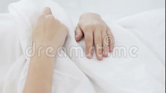 睡在舒适的床单上的女孩在舒适的床垫上做着平静而安静的梦视频的预览图