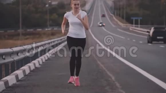 健康的生活方式一个穿着白色t恤和明亮运动鞋在城外跑步的年轻运动员关于视频的预览图