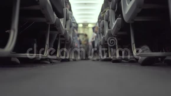 客舱飞机乘客坐在座位上空姐在飞行时走过道坐在经济舱的乘客视频的预览图