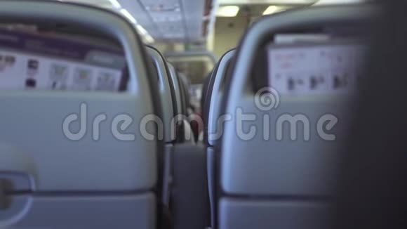在空中飞行时乘客坐在机舱内的现代飞机上乘坐经济舱商业飞机的乘客座位视频的预览图