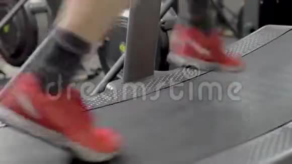 带着红色运动鞋在健身房跑步机上跑步视频的预览图