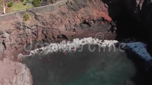 空中射击岩石火山岸蓝色的海浪在上面拍打在陆上设施和视频的预览图
