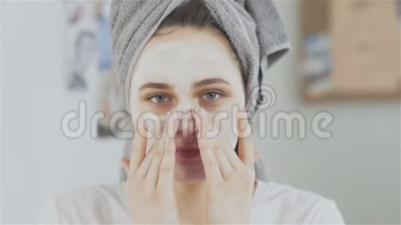 头戴毛巾的美女敷化妆面膜看镜头视频的预览图