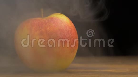 天然多汁的苹果在黑色背景的烟雾中吹出凉爽而新鲜的味道特写复制空间缓慢视频的预览图