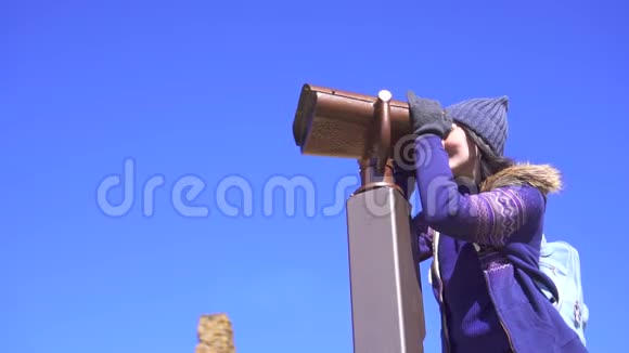 观景台上的女孩用望远镜望着群山慢悠悠地视频的预览图