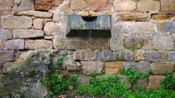 水从一条刻在石头上的水道里滴出来被困在一堵旧的砖墙里视频的预览图