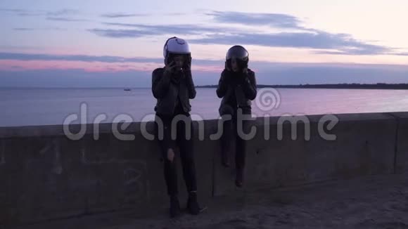两个年轻的骑自行车的人在旅行后从头上摘下头盔视频的预览图