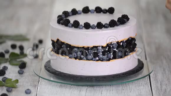 糖果师用蓝莓和黑莓装饰一个漂亮的蛋糕视频的预览图