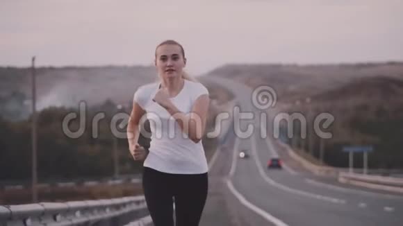 一个年轻的运动员穿着白色的t恤和明亮的运动鞋从城里跑出来健康的生活方式关于视频的预览图