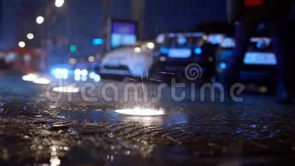 雨在缓慢的运动中落在城市街道上夜间有地面灯光视频的预览图