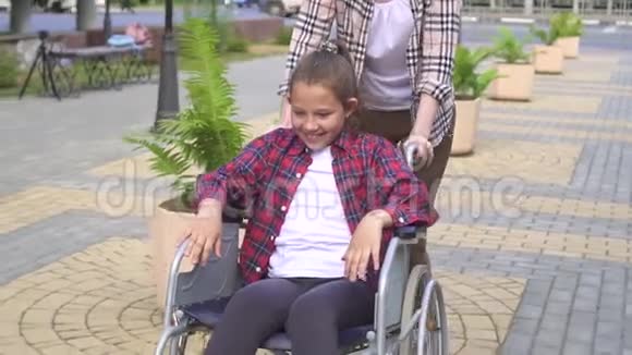 女孩骑着轮椅在夏季公园快乐少年慢节奏视频的预览图
