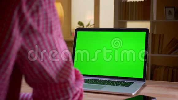 印度年轻商人在办公室室内使用带有绿色屏幕的笔记本电脑的特写后景拍摄视频的预览图