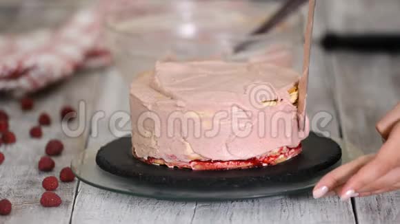 女孩把蛋糕上的奶油弄平了自制糕点烹饪糕点的概念视频的预览图