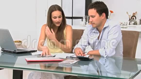 一对年轻夫妇在餐桌上谈论他们的债务视频的预览图