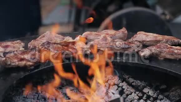 街市上铸铁烤架上的烤猪肉牛排视频的预览图