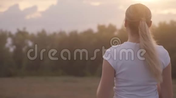积极休息景观优美一个穿着白色t恤的女孩在夕阳的照耀下逆天视频的预览图