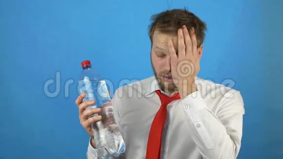 一个留着胡子和宿醉的白种人年轻人头上顶着一个冷水瓶头痛宿醉蓝色视频的预览图