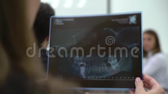 医学生医生拿着牙齿和下巴的X光片视频的预览图