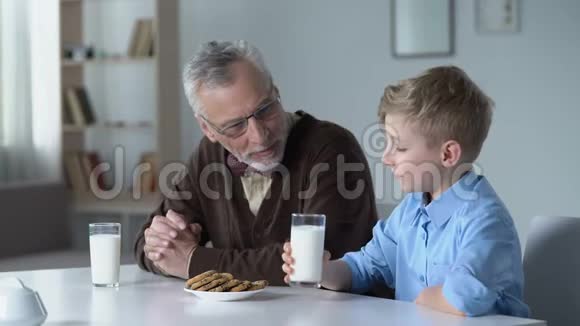 小孙子和爷爷碰杯牛奶营养午餐视频的预览图