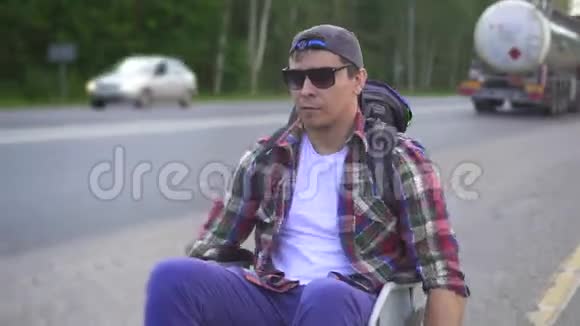 残疾人坐轮椅背着背包在高速公路上旅行关门视频的预览图