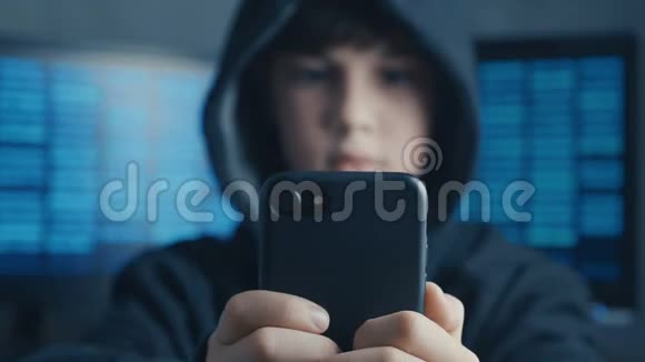 年轻的戴着头巾的男孩在数据中心使用智能手机设备天才少年惊奇黑客系统在网络空间的肖像视频的预览图