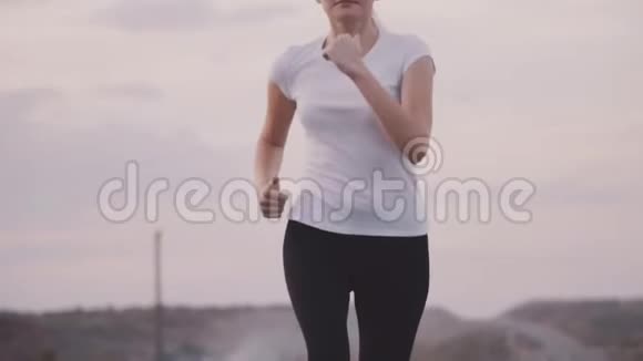 穿着白色t恤的运动女孩在高速公路上出城健康的生活方式在高速公路的背景下视频的预览图