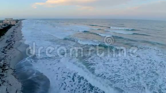 温暖的日落日出在平静的白色泡沫波可可海滩海岸线佛罗里达大西洋4k空中无人机视频的预览图