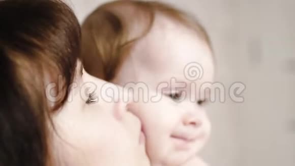 幸福的妈妈亲吻宝宝的脸颊幸福的家庭视频的预览图
