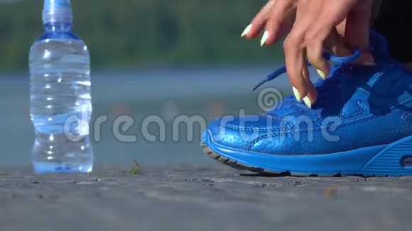 女跑步者准备系跑鞋的特写镜头视频的预览图