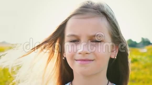 有魅力的小女孩的肖像大眼睛看着自然背景头发正在发育小女孩遮住了她的脸视频的预览图