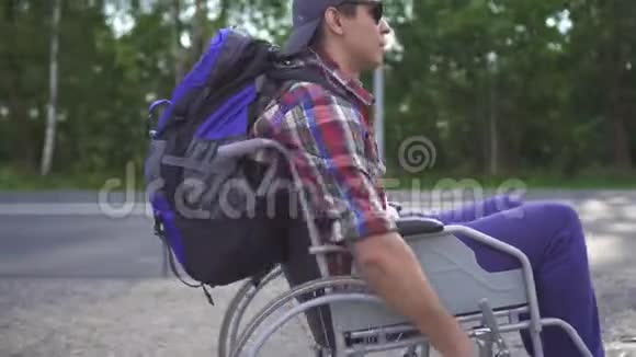 一个带背包的残疾人坐轮椅旅行的画像视频的预览图