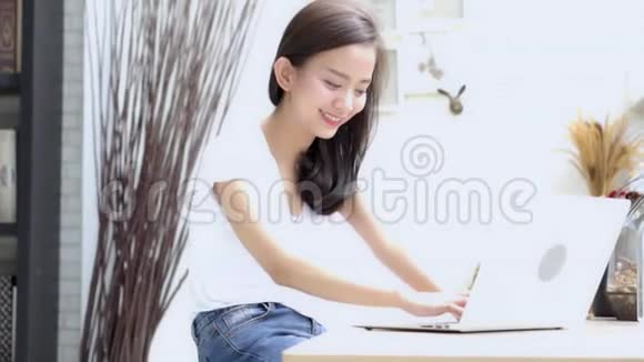 美丽的肖像亚洲年轻女子微笑着在网上工作开心地坐在咖啡店里视频的预览图