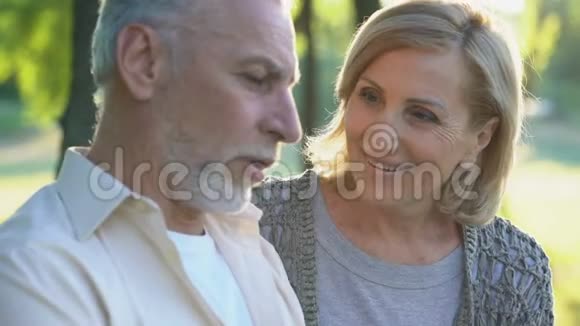 60多岁的美女温柔地亲吻着退休的男性幸福的老年夫妇视频的预览图