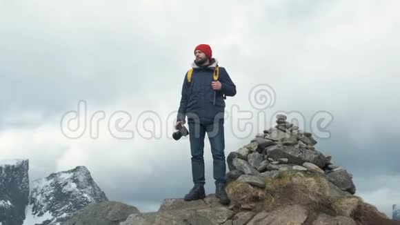 专业摄影师男性带单反背包拍摄山谷风景视频的预览图