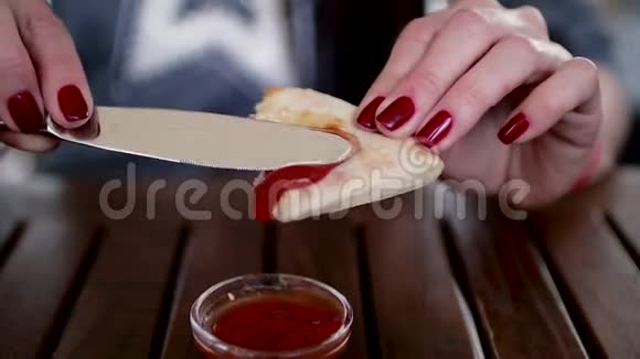 女孩手里拿着面包在上面涂上番茄酱或酱汁视频的预览图