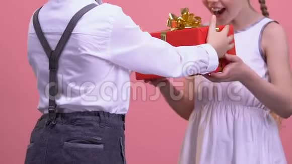 小男孩送礼物给惊喜的女孩庆祝生日聚会视频的预览图
