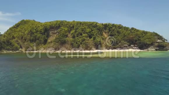 鸟瞰绿色热带岛屿有山脉沙滩和钓鱼屋视频的预览图