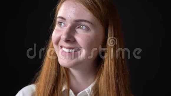 迷人的快乐年轻女子姜发带着牙齿微笑被隔离在黑色的工作室背景上视频的预览图