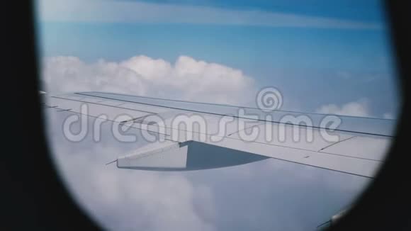 雄伟的宁静从飞机窗口座位飞行飞机机翼飞行在惊人的白云上方蓝天视频的预览图