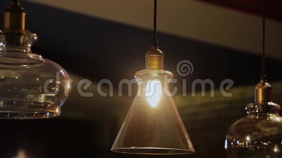 老式和复古黄色灯泡悬挂在黑暗背景在咖啡馆晚上许多豪华灯灯装饰视频的预览图